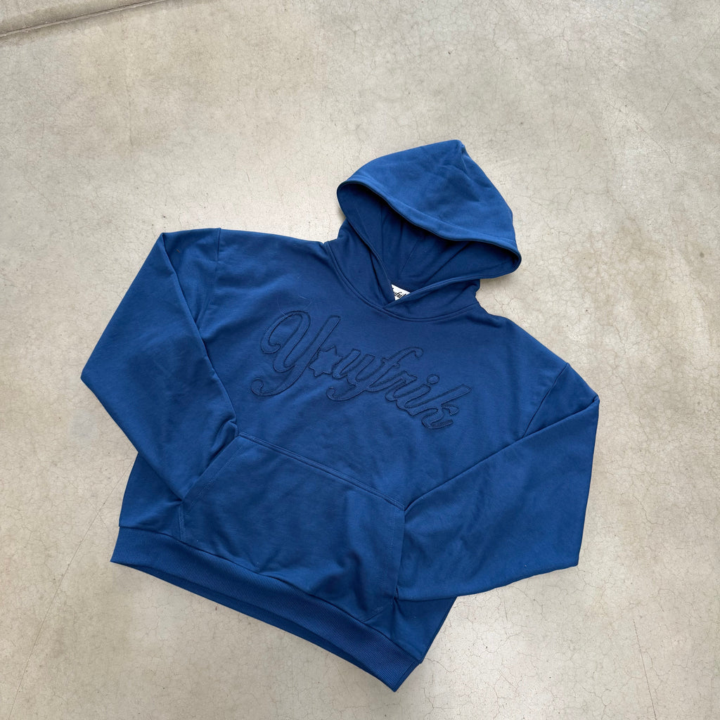 Blauer Pullover der auf dem Boden liegt